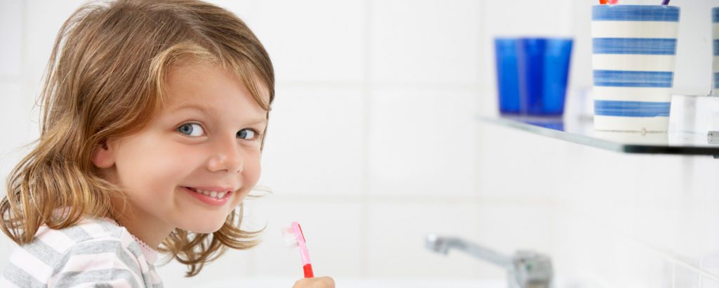 Girl brushing her teeth and smiling